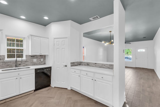 kitchen with pendant lighting, black dishwasher, sink, white cabinetry, and backsplash