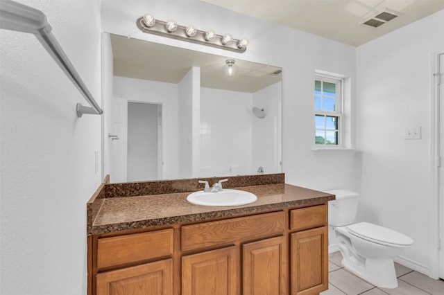 bathroom featuring tile patterned floors, walk in shower, vanity, and toilet