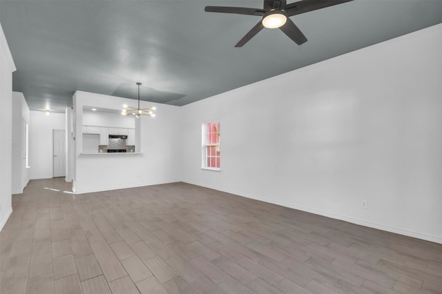 unfurnished living room with light wood-type flooring and ceiling fan with notable chandelier