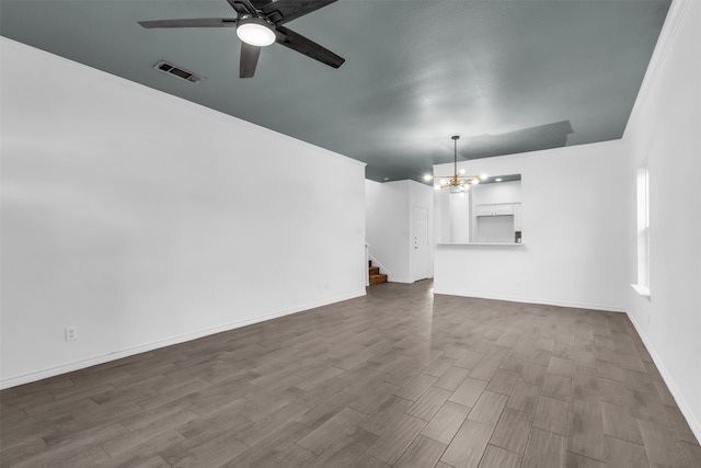 unfurnished living room with ceiling fan with notable chandelier and hardwood / wood-style flooring