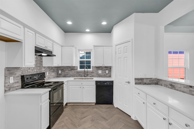 kitchen featuring decorative backsplash, white cabinets, light parquet floors, black appliances, and sink