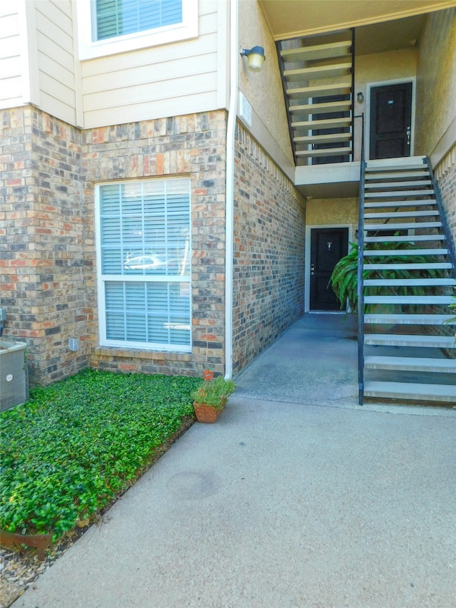 property entrance featuring central AC unit and a patio