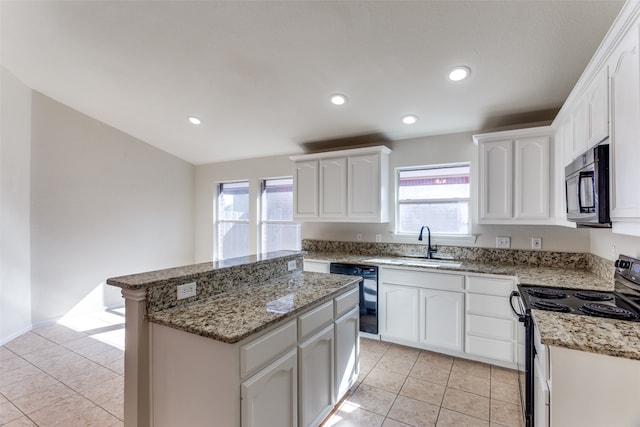 kitchen featuring white cabinetry, a kitchen island, a wealth of natural light, and black appliances