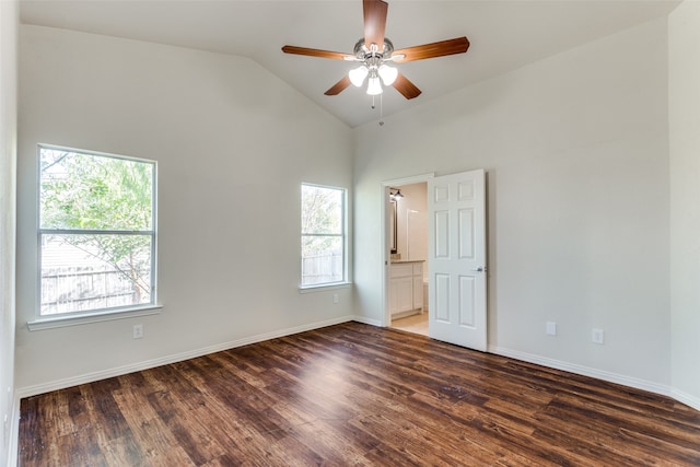 spare room featuring dark hardwood / wood-style flooring, plenty of natural light, and lofted ceiling