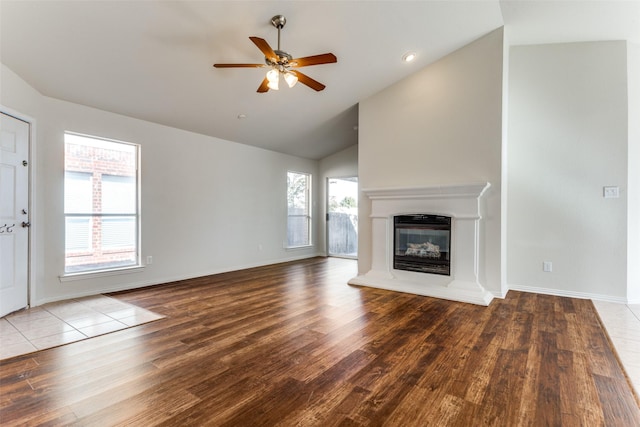 unfurnished living room featuring high vaulted ceiling, light hardwood / wood-style flooring, a wealth of natural light, and ceiling fan