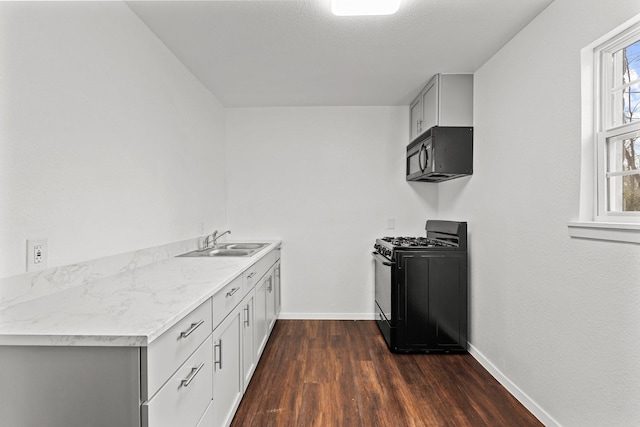 kitchen featuring black appliances, dark hardwood / wood-style floors, and sink