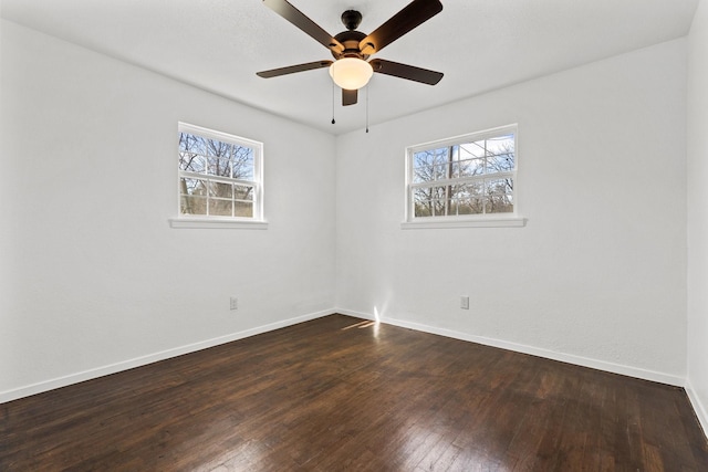 unfurnished room featuring ceiling fan, plenty of natural light, and dark wood-type flooring