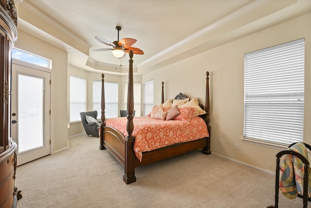 carpeted bedroom featuring a raised ceiling, ceiling fan, and crown molding