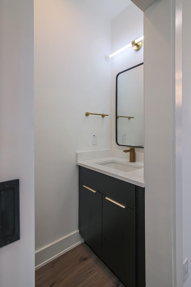 3143 Mcdermott Ave, Dallas, TX 75215 - bathroom featuring wood finished floors, vanity, and baseboards