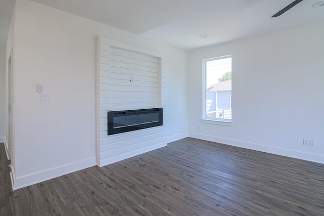 3143 Mcdermott Ave, Dallas, TX 75215 - unfurnished living room with a large fireplace, dark wood-type flooring, baseboards, and a ceiling fan