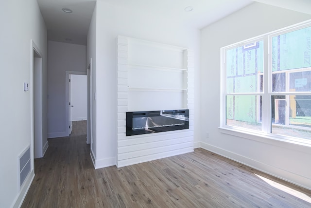 unfurnished living room with a healthy amount of sunlight and wood-type flooring