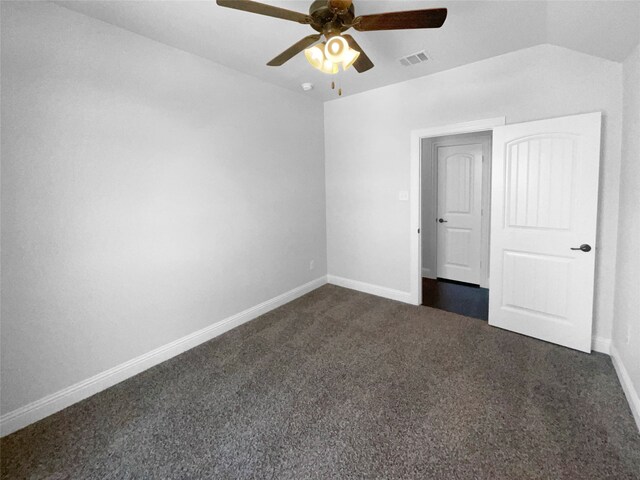 interior space featuring ceiling fan, lofted ceiling, and dark colored carpet