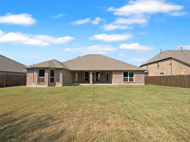 rear view of house featuring a yard and a patio