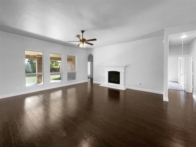 unfurnished living room featuring ceiling fan and dark wood-type flooring