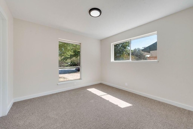 carpeted spare room featuring baseboards