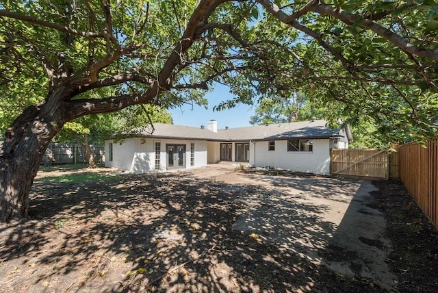 view of front facade featuring a gate, fence, and french doors