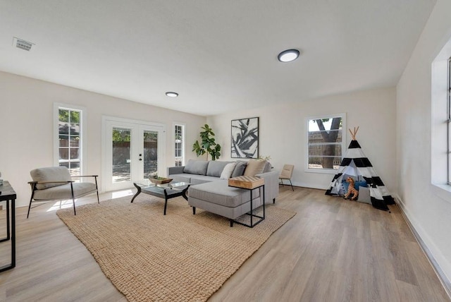 living room with french doors and light hardwood / wood-style floors