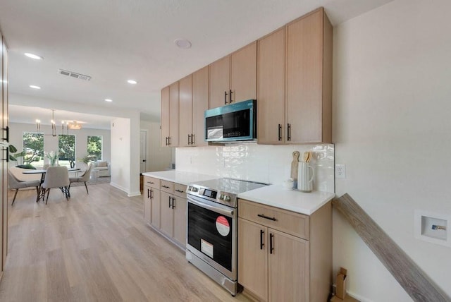 kitchen featuring light brown cabinets, visible vents, appliances with stainless steel finishes, light wood-type flooring, and tasteful backsplash