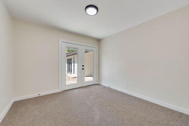 empty room with french doors, carpet flooring, and baseboards