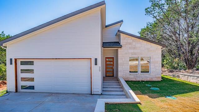 contemporary home with a garage and a front yard