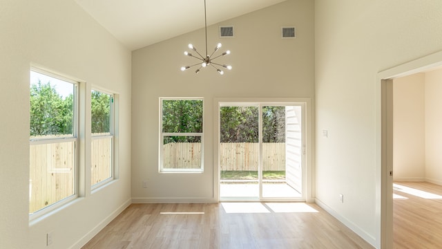 interior space with high vaulted ceiling, a wealth of natural light, and light hardwood / wood-style flooring