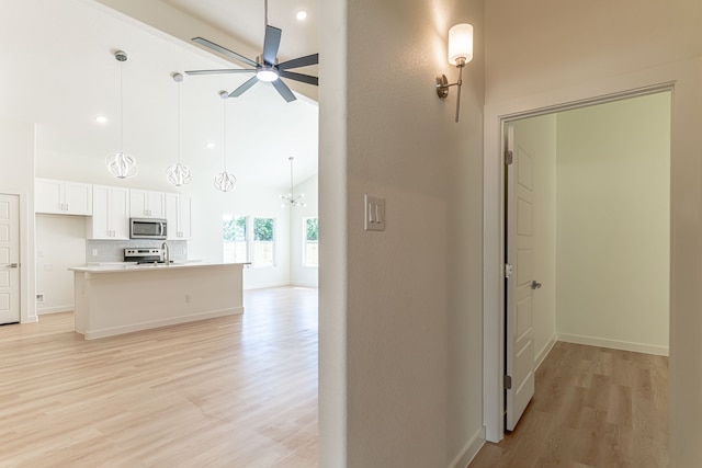 interior space featuring light wood-type flooring, a high ceiling, and sink