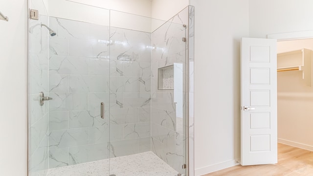 bathroom featuring wood-type flooring and a shower with shower door