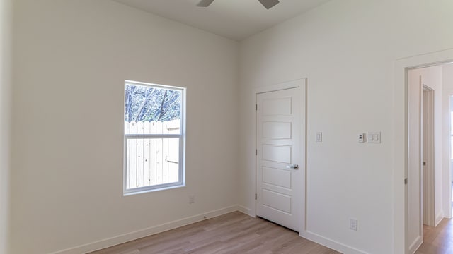 empty room with ceiling fan and light hardwood / wood-style floors