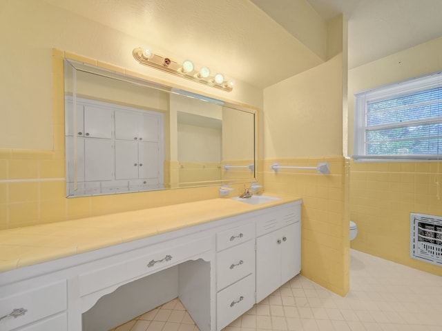 bathroom featuring tile walls, vanity, toilet, and heating unit