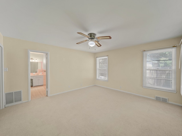 carpeted spare room with a wealth of natural light and ceiling fan