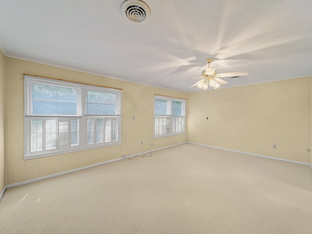 empty room with crown molding, light carpet, and ceiling fan