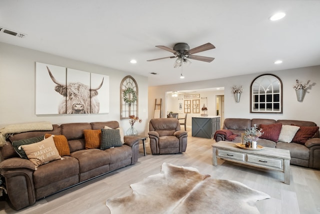 living room with light wood-type flooring and ceiling fan