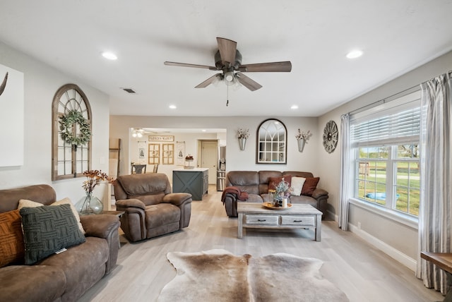 living room featuring light wood-type flooring and ceiling fan