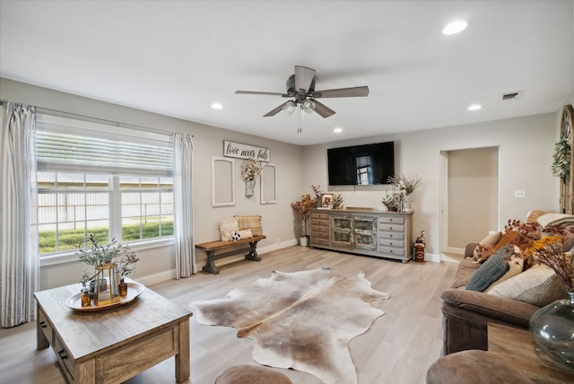 living room featuring ceiling fan and light hardwood / wood-style flooring