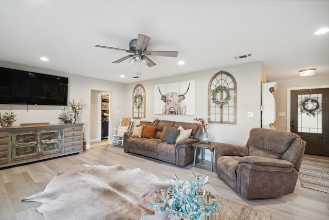 living room featuring a healthy amount of sunlight, light hardwood / wood-style floors, and ceiling fan