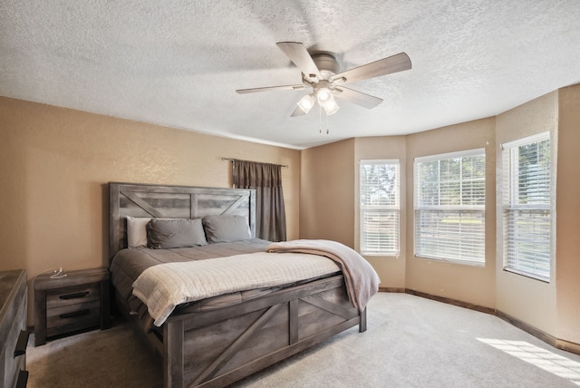 bedroom with light carpet, ceiling fan, and a textured ceiling