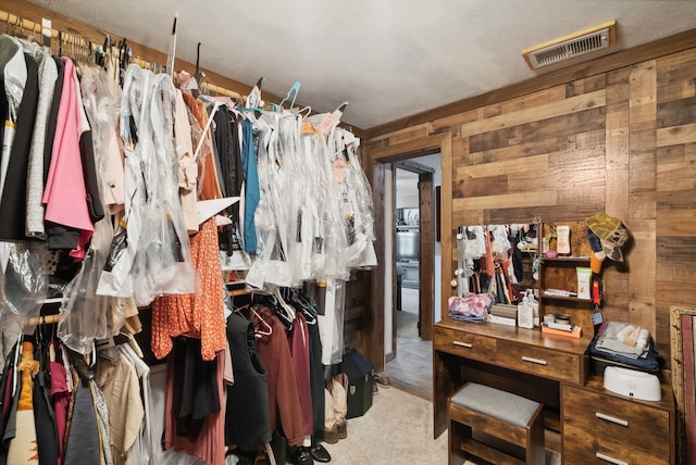 spacious closet featuring light colored carpet