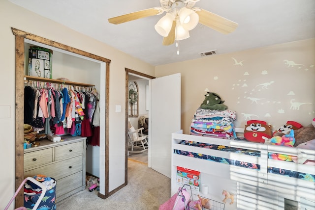 carpeted bedroom featuring ceiling fan and a closet