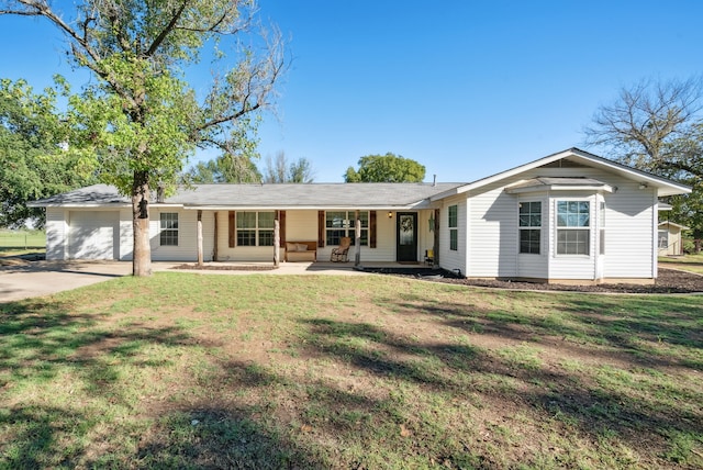 ranch-style home with a front lawn, covered porch, and a garage