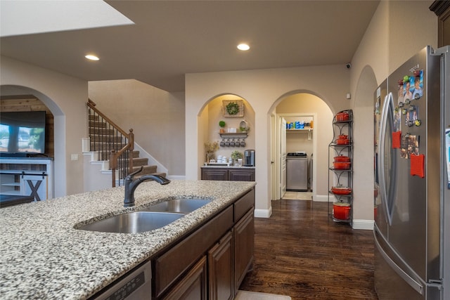 kitchen featuring dark hardwood / wood-style floors, sink, light stone counters, stainless steel appliances, and dark brown cabinets