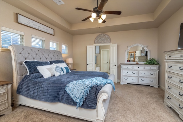 carpeted bedroom featuring ceiling fan and a raised ceiling