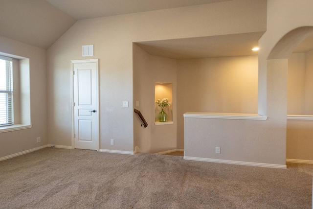 unfurnished room featuring lofted ceiling and carpet