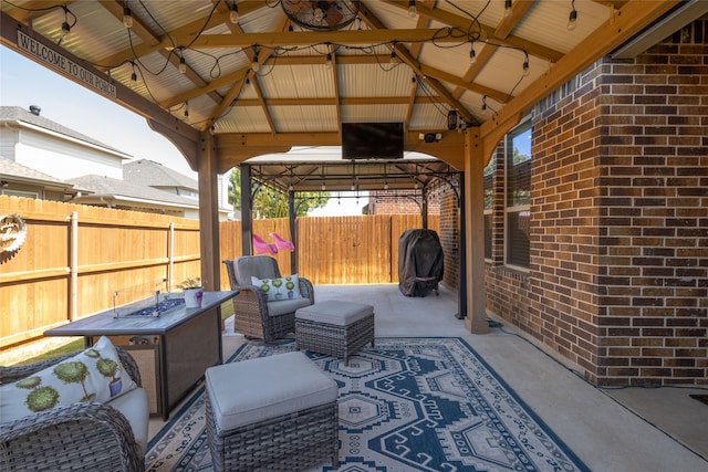 view of patio with a gazebo and an outdoor living space with a fire pit