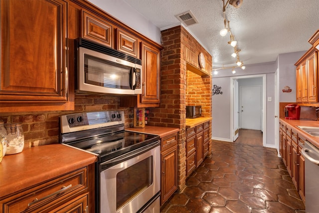 kitchen featuring a textured ceiling, appliances with stainless steel finishes, and sink