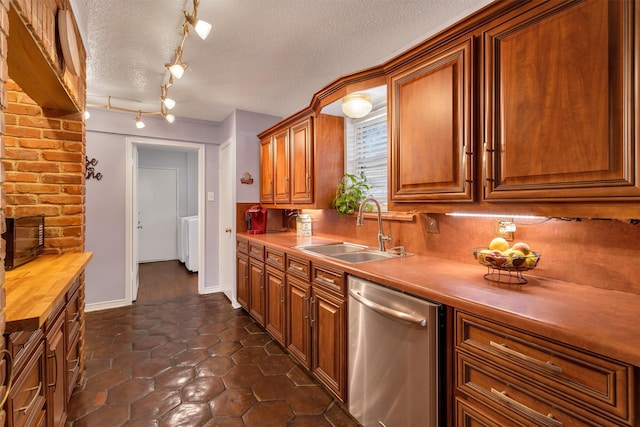 kitchen with a textured ceiling, backsplash, sink, and stainless steel dishwasher