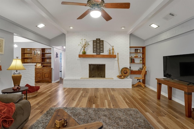 living room with wood-type flooring, vaulted ceiling with beams, ceiling fan, and a fireplace