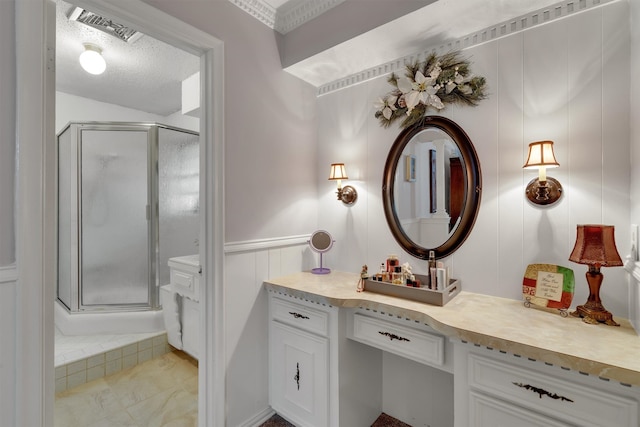 bathroom with walk in shower, vanity, and a textured ceiling