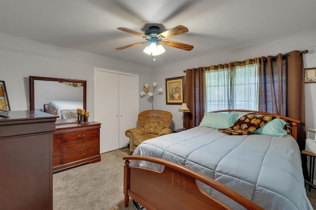 bedroom featuring ceiling fan, light colored carpet, and a closet