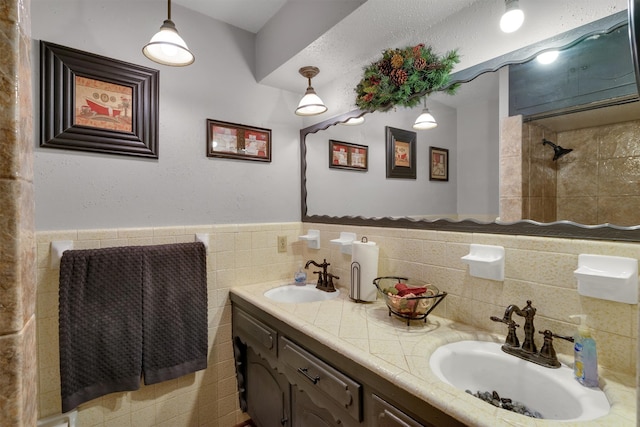 bathroom with vanity, tile walls, and tiled shower