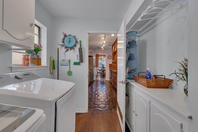 laundry room with cabinets, washer and clothes dryer, dark wood-type flooring, and a textured ceiling